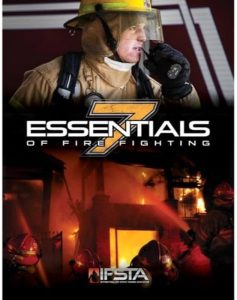 Cover of "Essentials of Fire Fighting" featuring a firefighter in full gear speaking into a radio, with a background of a blazing fire and several firefighters battling the flames. The number 7 is prominently displayed.